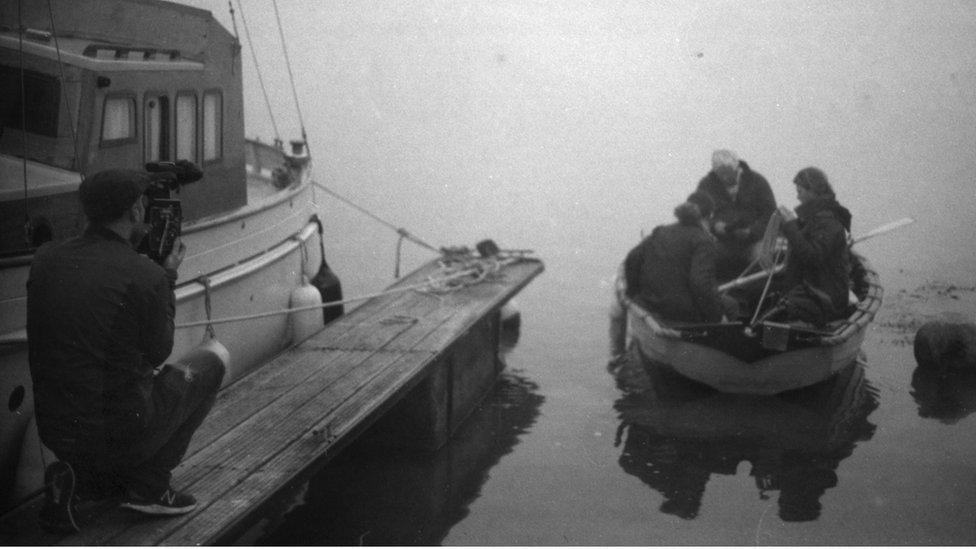 Huw Wahl filming people on a smaller boat