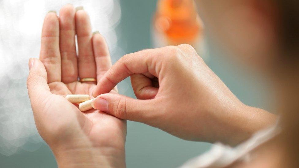 Woman with herbal pills in her hand