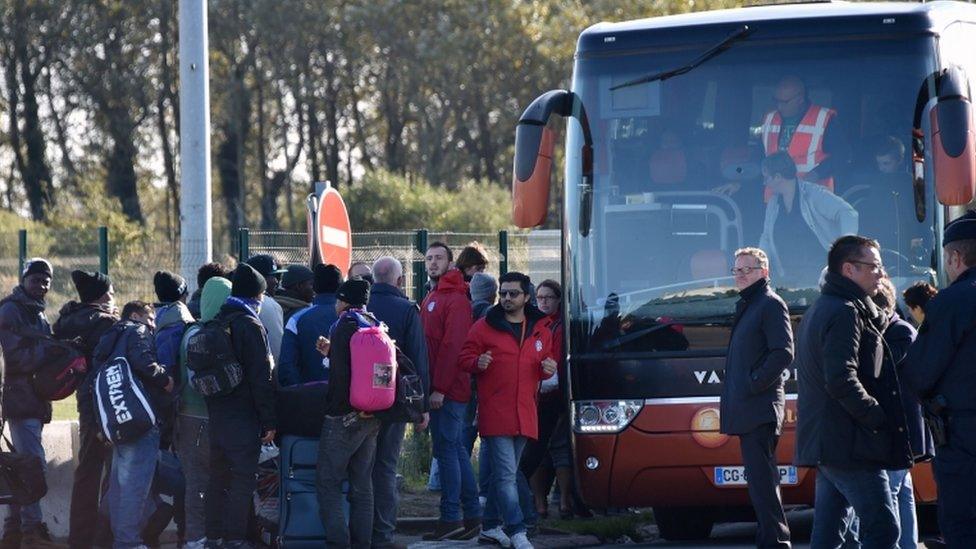 Migrants queue to board a bus leaving the Calais 'Jungle' on 28 October, 2016.