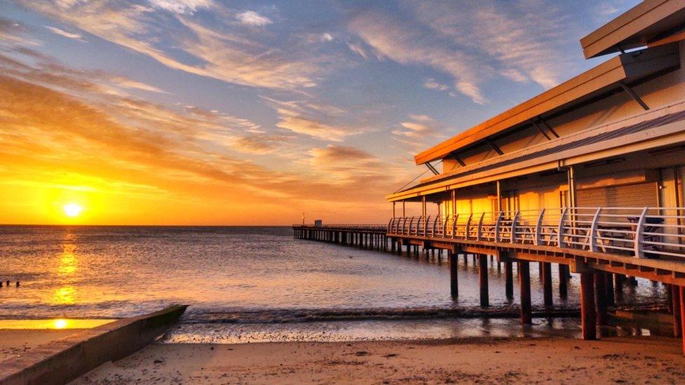 Sunrise over the Suffolk cast with a pier on the right hand side