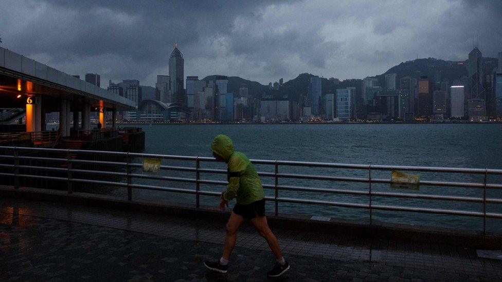 A man jogs along a promenade running along Victoria Harbour as Typhoon Haima approaches Hong Kong early on 21 October 2016.