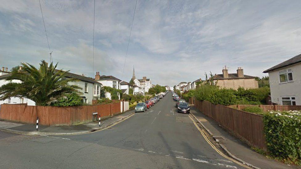 A Google Steet View of Wood Street, Ryde, taken from one end looking down. There are several cars parked on either side of the road and there are double yellow lines on both corners