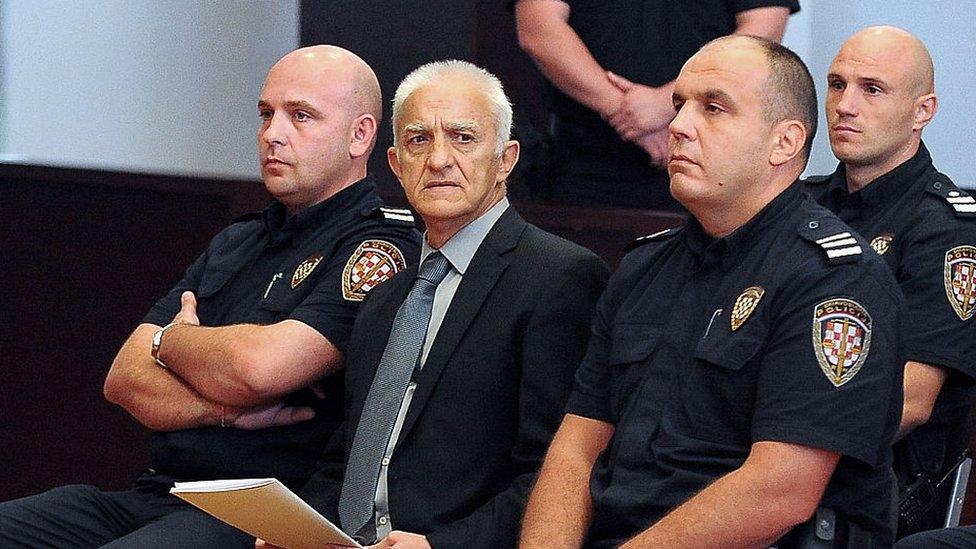 Dragan Vasiljkov sits flanked by policemen