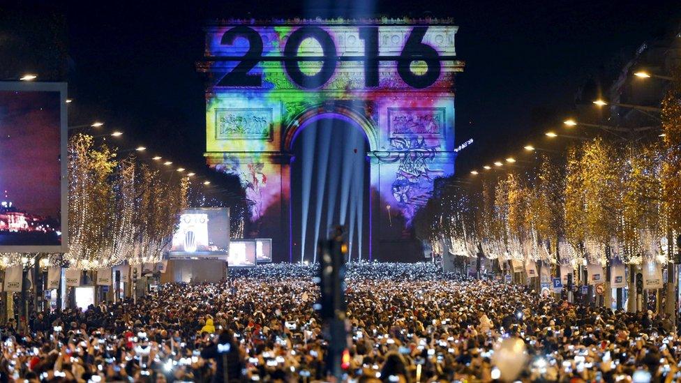 Revellers gather near the Arc de Triomphe on the Champs Elysees Avenue in Paris during New Year celebrations