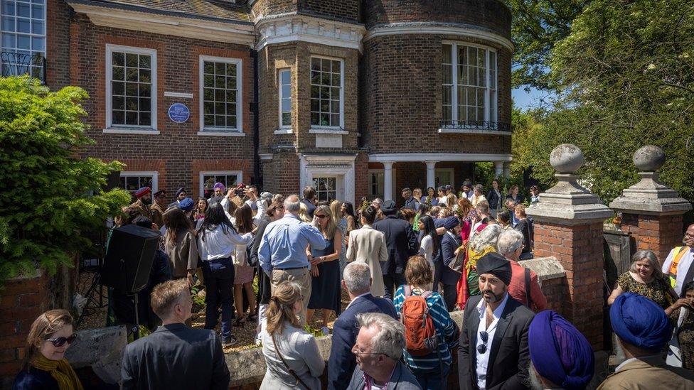 People in the sunshine underneath Princess Sophia's plaque at Faraday House