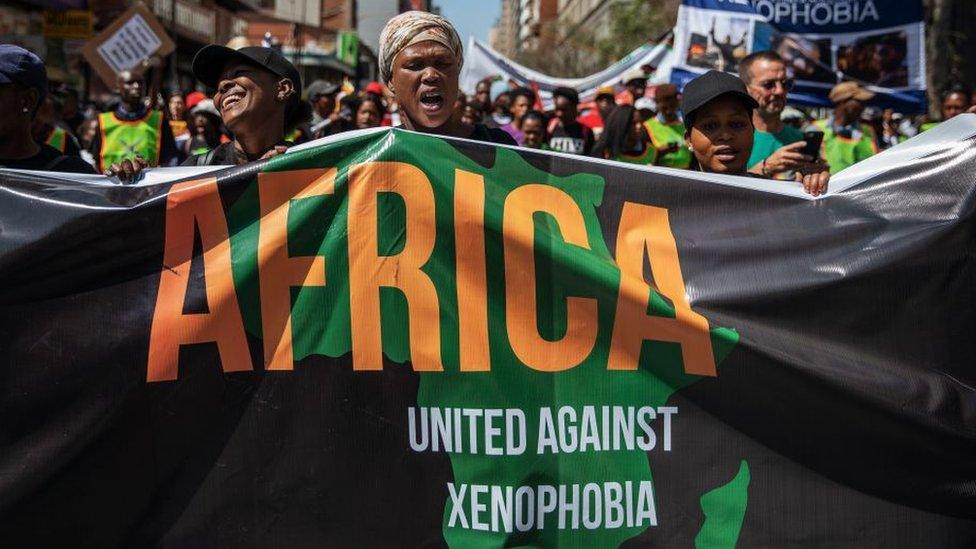 Woman with anti-xenophobia banner