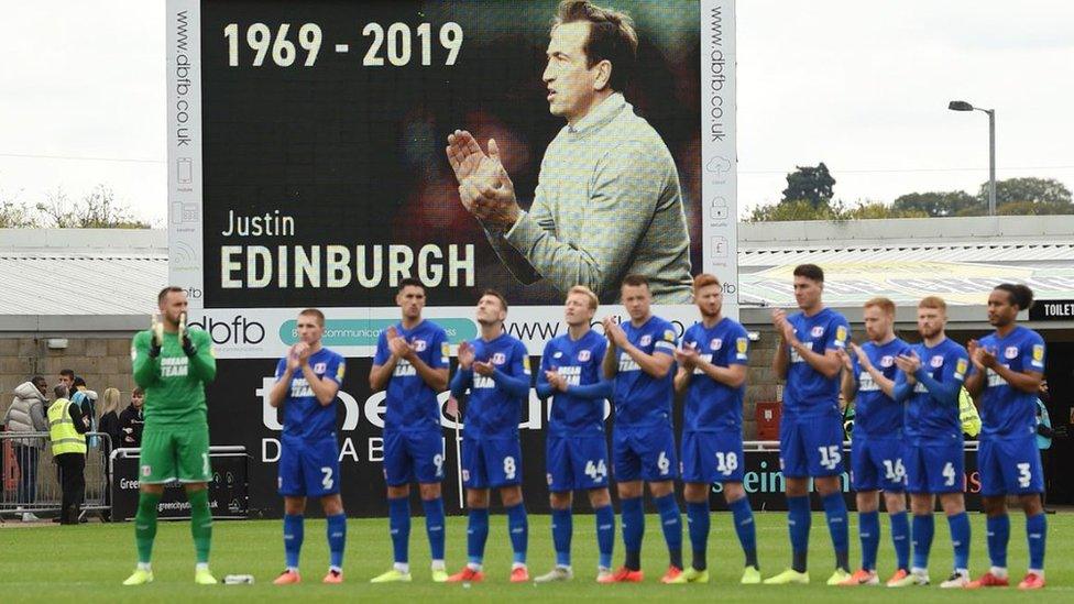 Football players hold an applause for Justin Edinburgh.