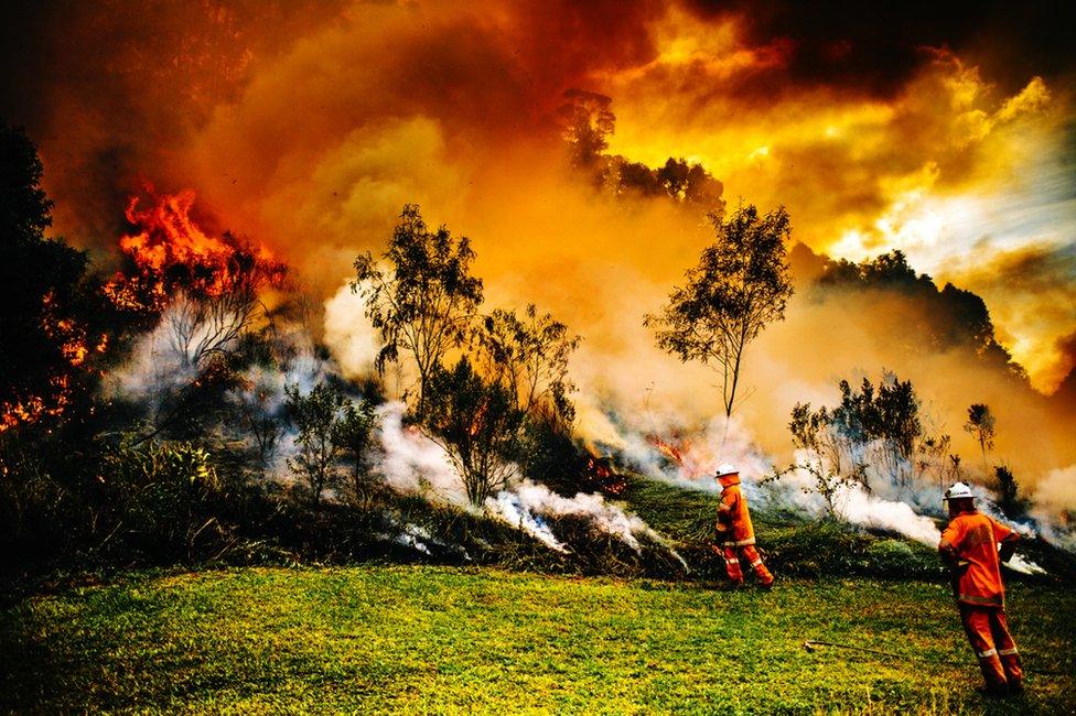 Firefighters battle a blaze on a hill