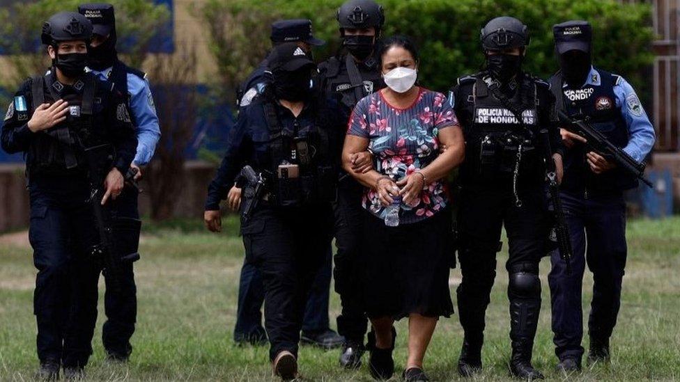 Police officers escort cartel leader Herlinda Bobadilla following an extradition request for her and her sons by the United States, in Tegucigalpa, Honduras May 15, 2022.