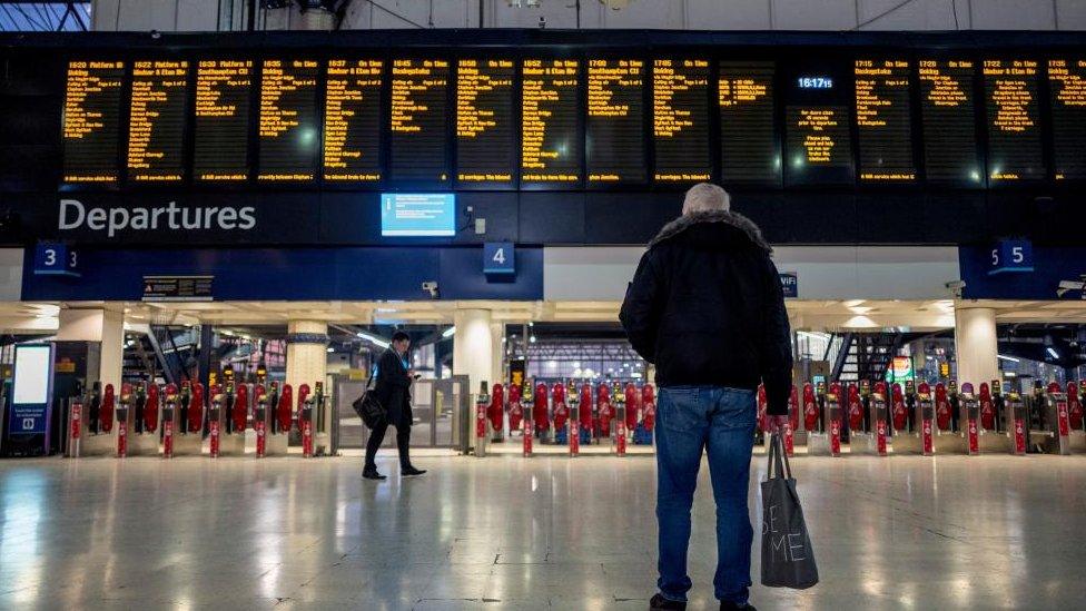 Man looks at departure board at station