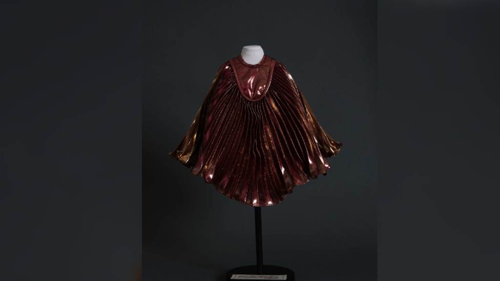 A miniature mannequin wearing a replica of a cape worn by Queen singer Fredd