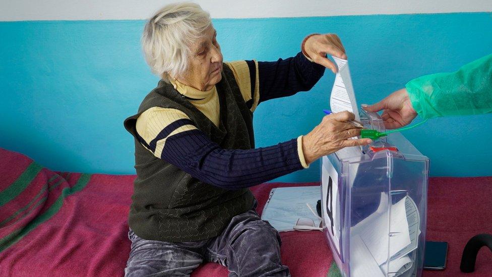 A woman casts her ballot during voting in a so-called referendum on the joining of Russian-controlled regions of Ukraine to Russia, in a hospital in Berdyansk, Zaporizhzhia region