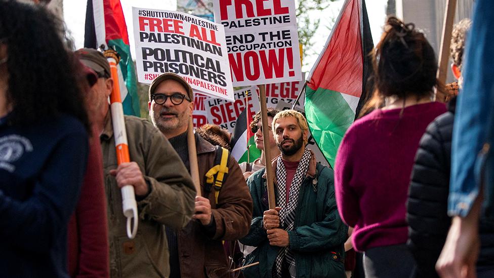 Protesters carry placards outside Columbia University in New York on 23 April