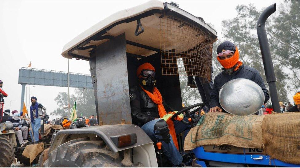 Farmers sit on a tractor at the frontline of the protest site as they march towards New Delhi to press for better crop prices promised to them in 2021, at Shambhu barrier, a border crossing between Punjab and Haryana states, India, February 21, 202