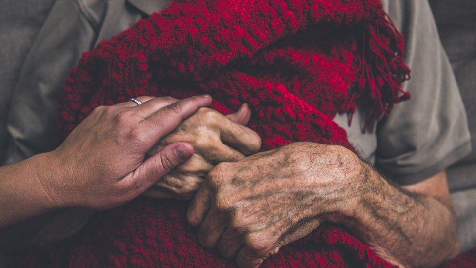 A hospice nurse visiting an elderly male patient who is receiving hospice/palliative care