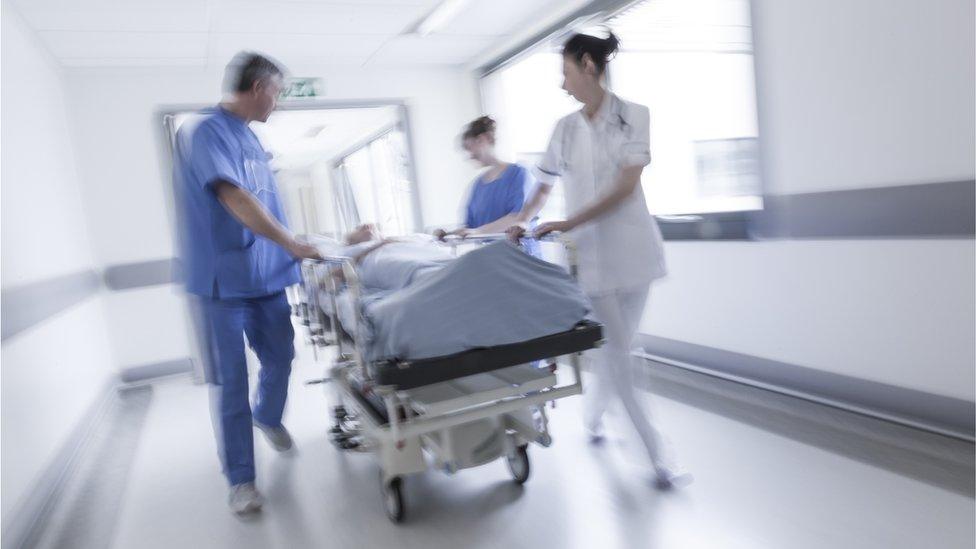 Hospital staff with patient on trolley