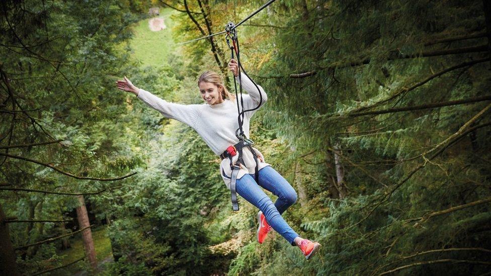 A woman in a Go Ape harness