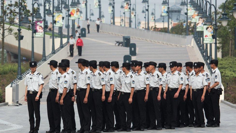 Security men line up in front of the Shanghai Disney Resort in Shanghai on June 15, 2016.