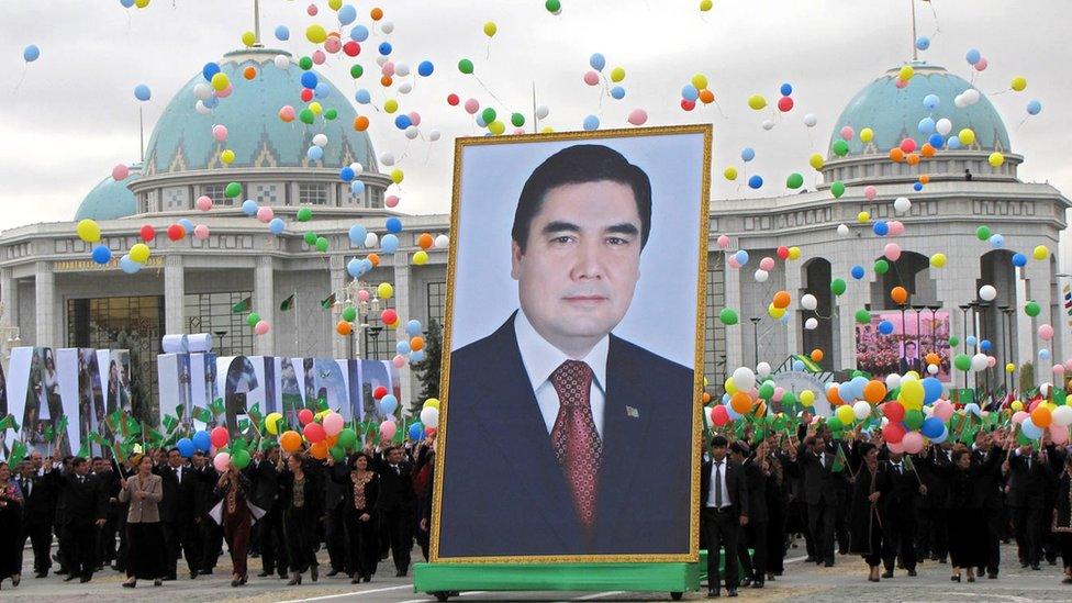 People carry a picture of Turkmen President Kurbanguly Berdymukhammedov to mark Turkmenistan's Independence Day in Ashgabat on 27 October 2009