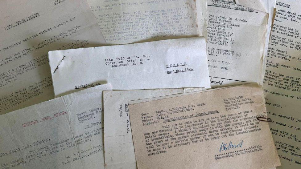 About eight wartime type written documents laid on top of each other so some of each can be seen. They include details of exercises, an award for good contact, and a plan of action. 