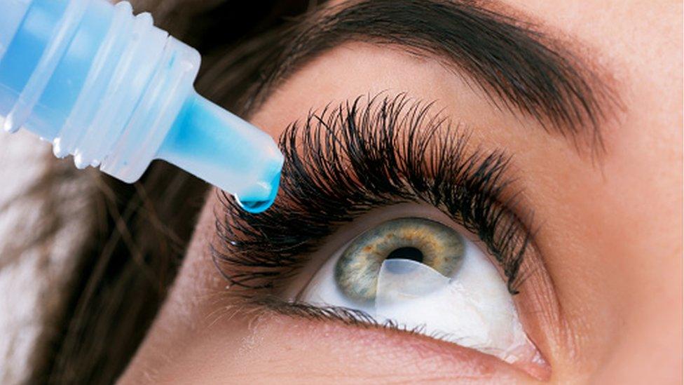 A woman using eye drops