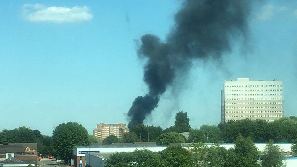 The plume of black smoke in the wind