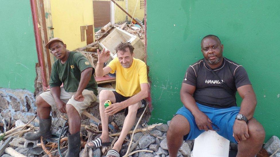 Wyfee Joules and his friends sit on the steps of what was once his bar.