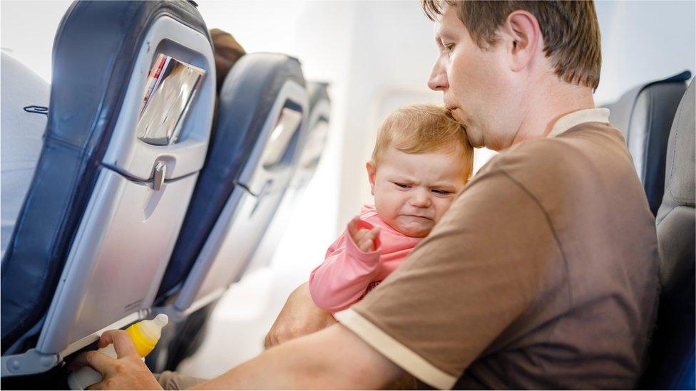 Unhappy baby on plane with dad