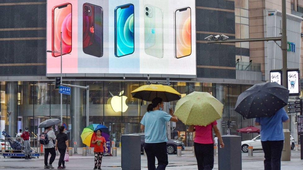 iPhone smartphones seen displayed on a large screen outside the Apple store on Wangfujing Street in Beijing.