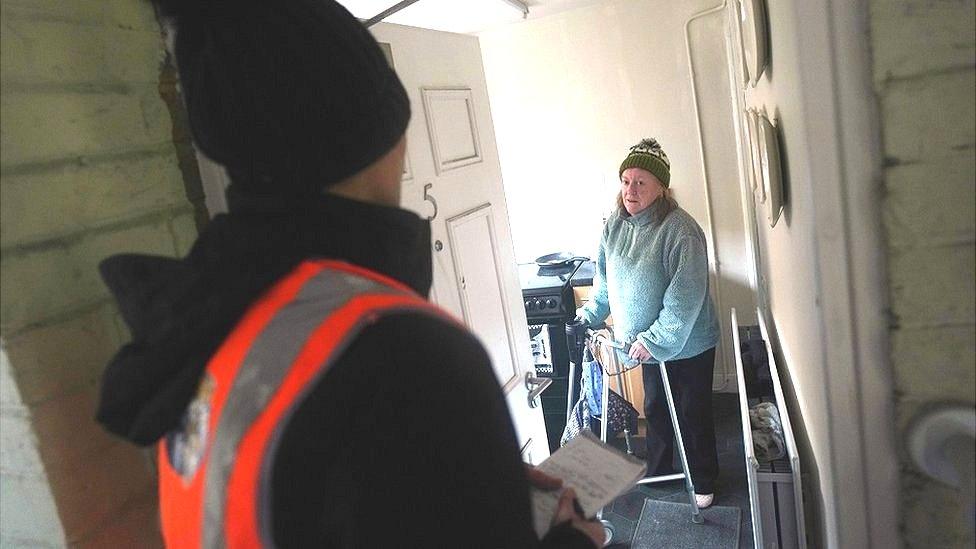 An official talks to a resident affected by Storm Arwen