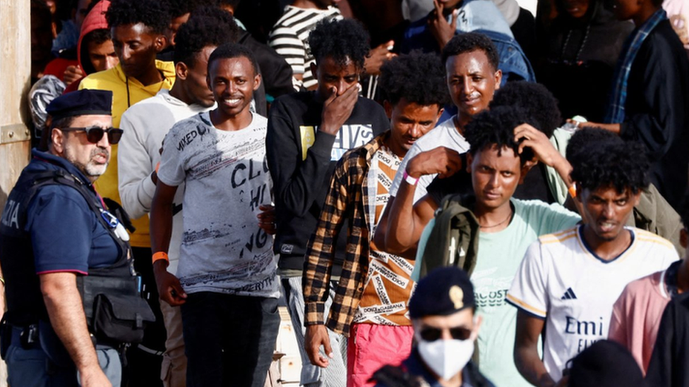 Migrants rescued at sea walk after disembarking from a vessel, on the Sicilian island of Lampedusa