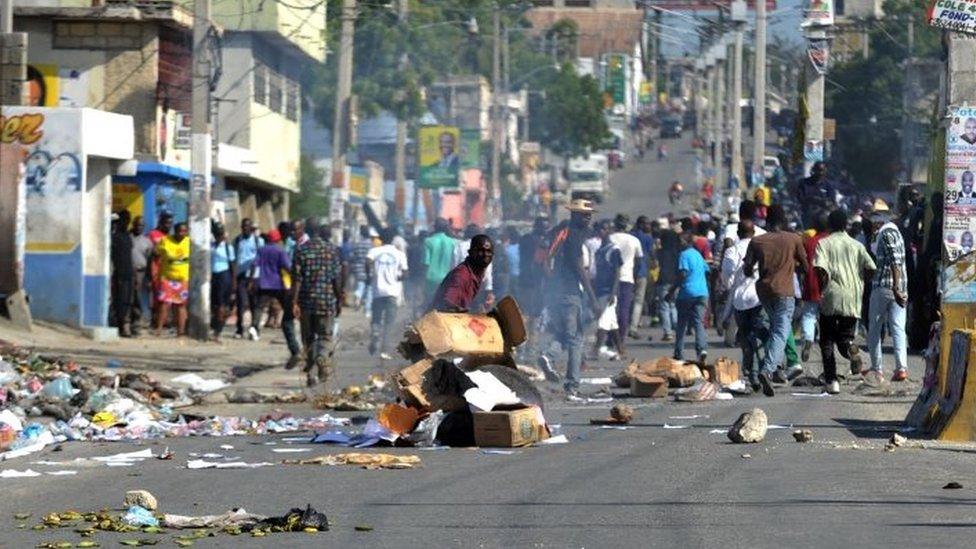 Demonstrators place barricades on the street during a march in Port-au-Prince on 24 November, 2015.