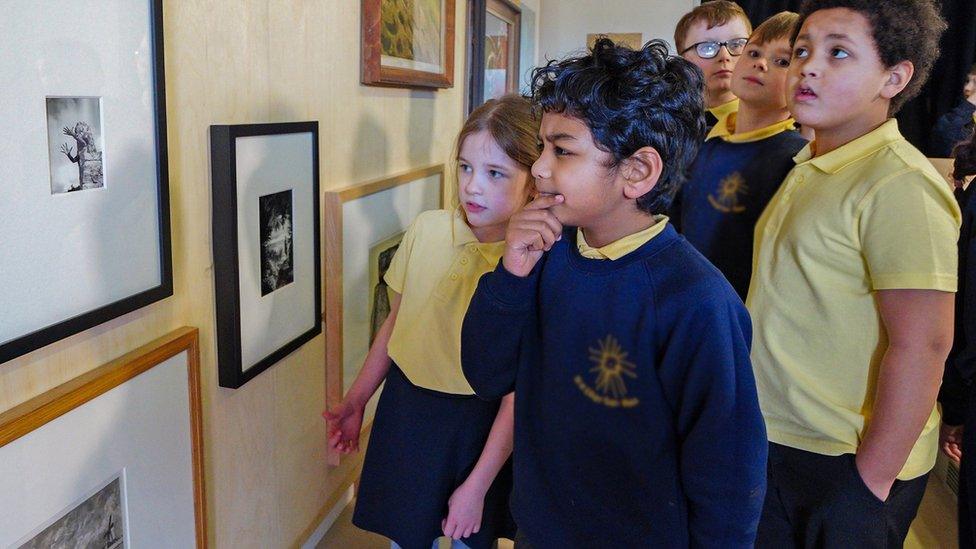 Children look at art in an exhibition