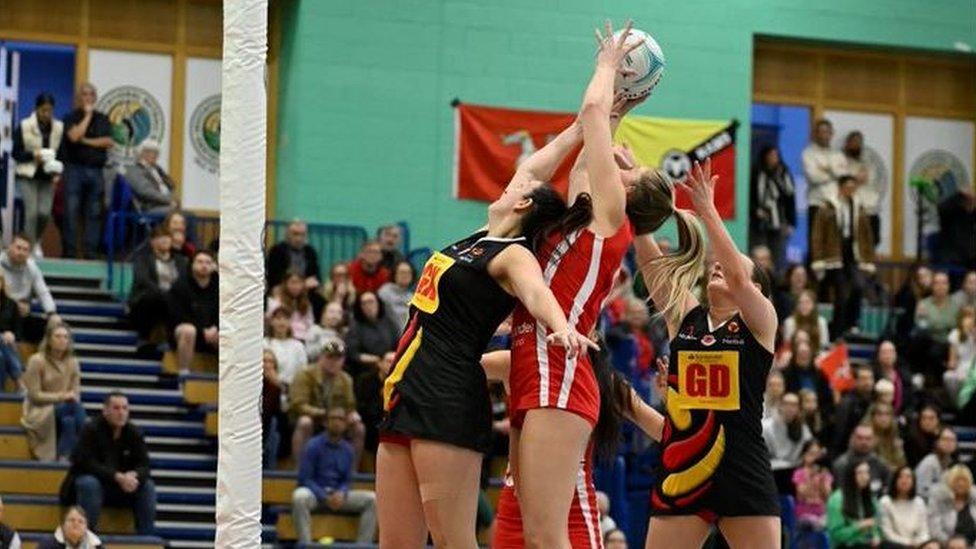 Netball players jumping for the ball