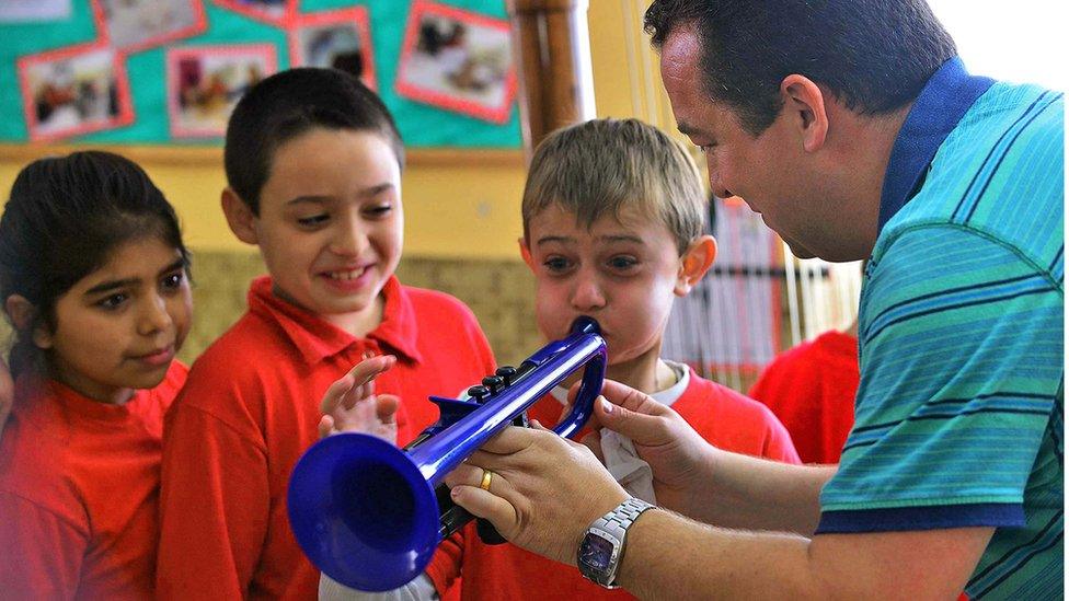 Trying out a toy trumpet