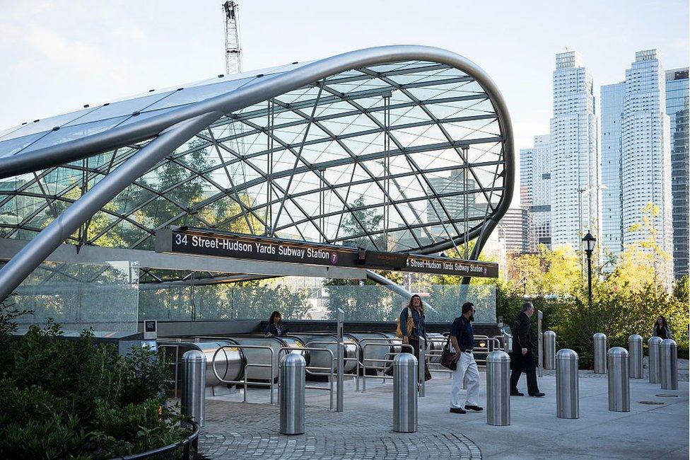 The entrance to the "34th Street, Hudson Yards" subway station with skyscrapers in the distance