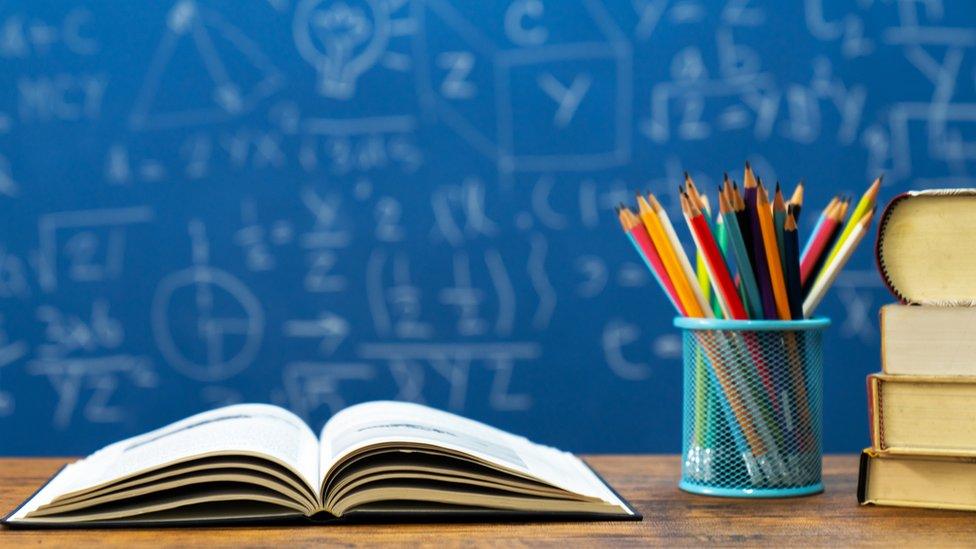 A book and coloured pencils on a desk