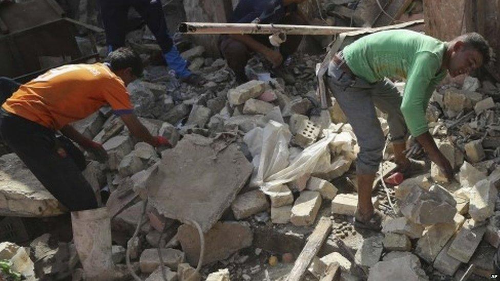 Youths go through the debris from Friday night's suicide car bombing at a busy market in Khan Beni Saad, (18 July 2015)