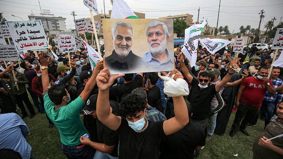 A protesters holds a picture showing the face of slain Iranian commander Qasem Soleimani