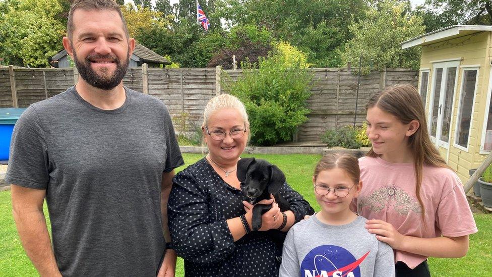 Matt in the garden with his family wife Sarah daughters Erin and Ellie and 12 week old Jack-A-Poo puppy Ember