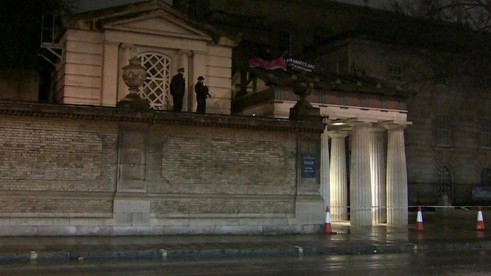 Police stand guard as activists stay on roof of the Queen's Gallery at Buckingham Palace on 28 November 2015