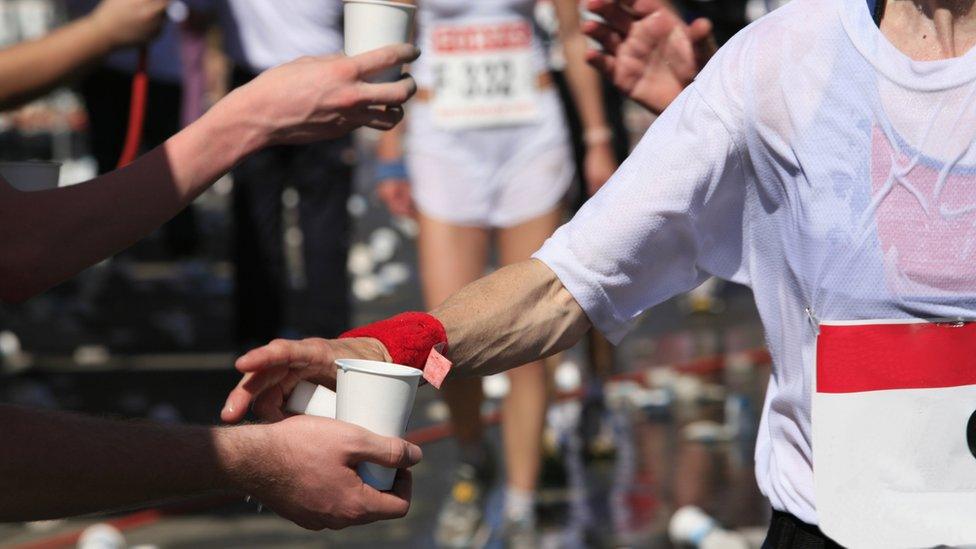 A distance runner getting a drink