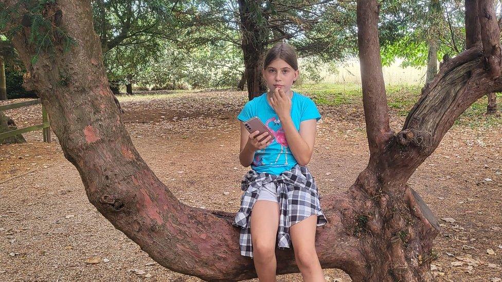 Bethany sitting on a tree branch