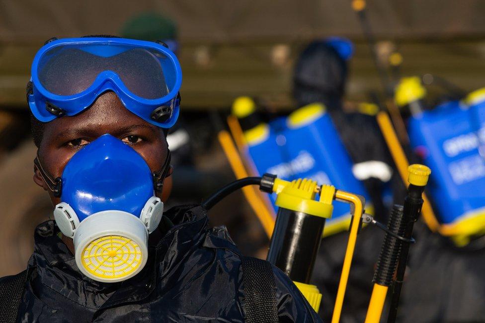 A soldier prepares equipment to spray crops