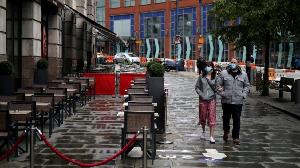 Couple walking past bar in Manchester