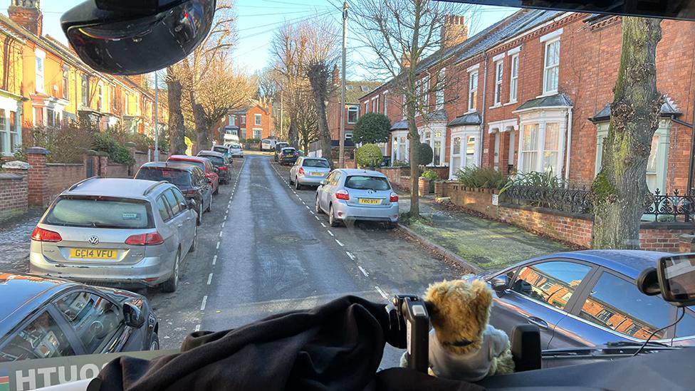 View of parked cars from fire engine cab