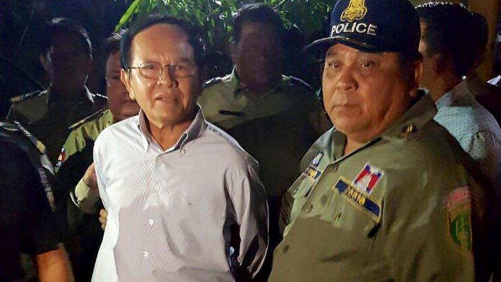 Cambodian opposition leader Kem Sokha (L) is escorted by police at his home in Phnom Penh on September 3, 2017.