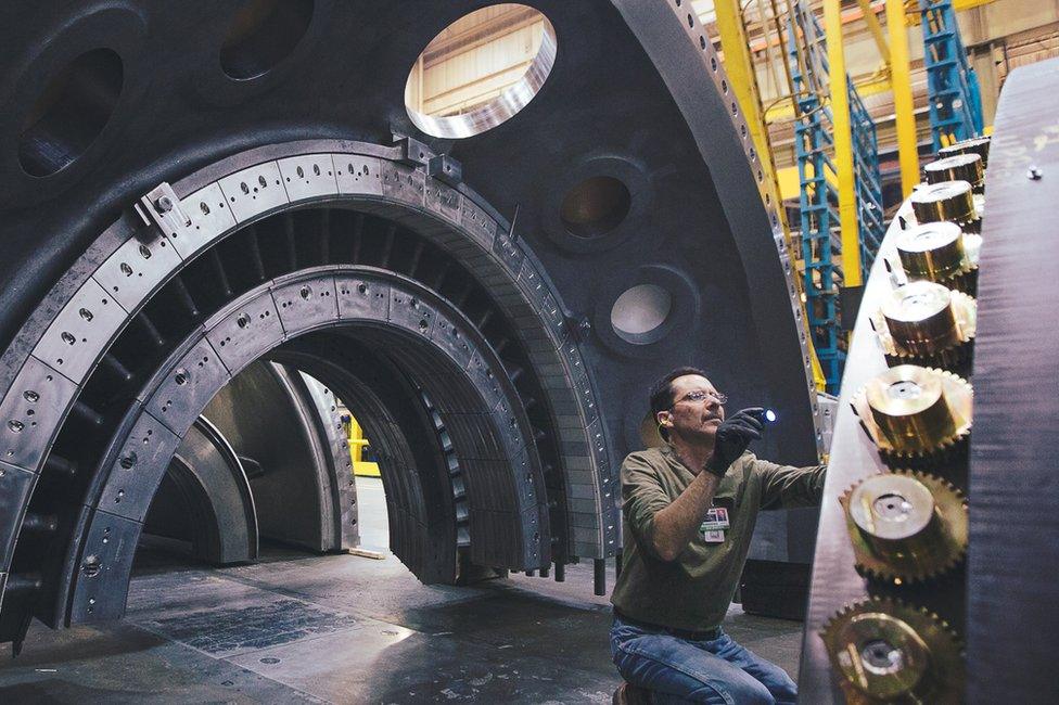 Engineer inspecting big machine parts