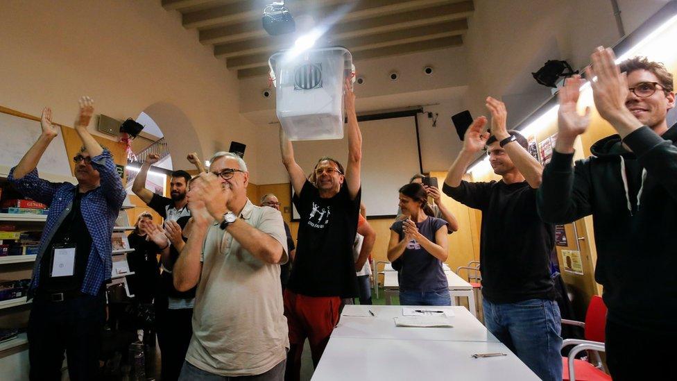 People celebrate after the closing of polling stations outside the "Espai Jove La Fontana" (La Fontana youth centre) on October 1, 2017 in Barcelona