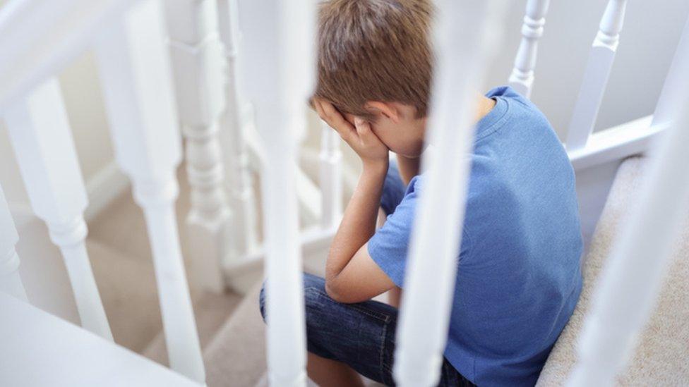 boy holding his head in his hands